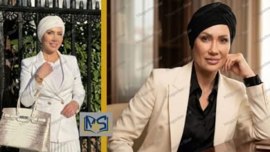 Portrait of Emily Abraham wearing a beige blazer and black headscarf